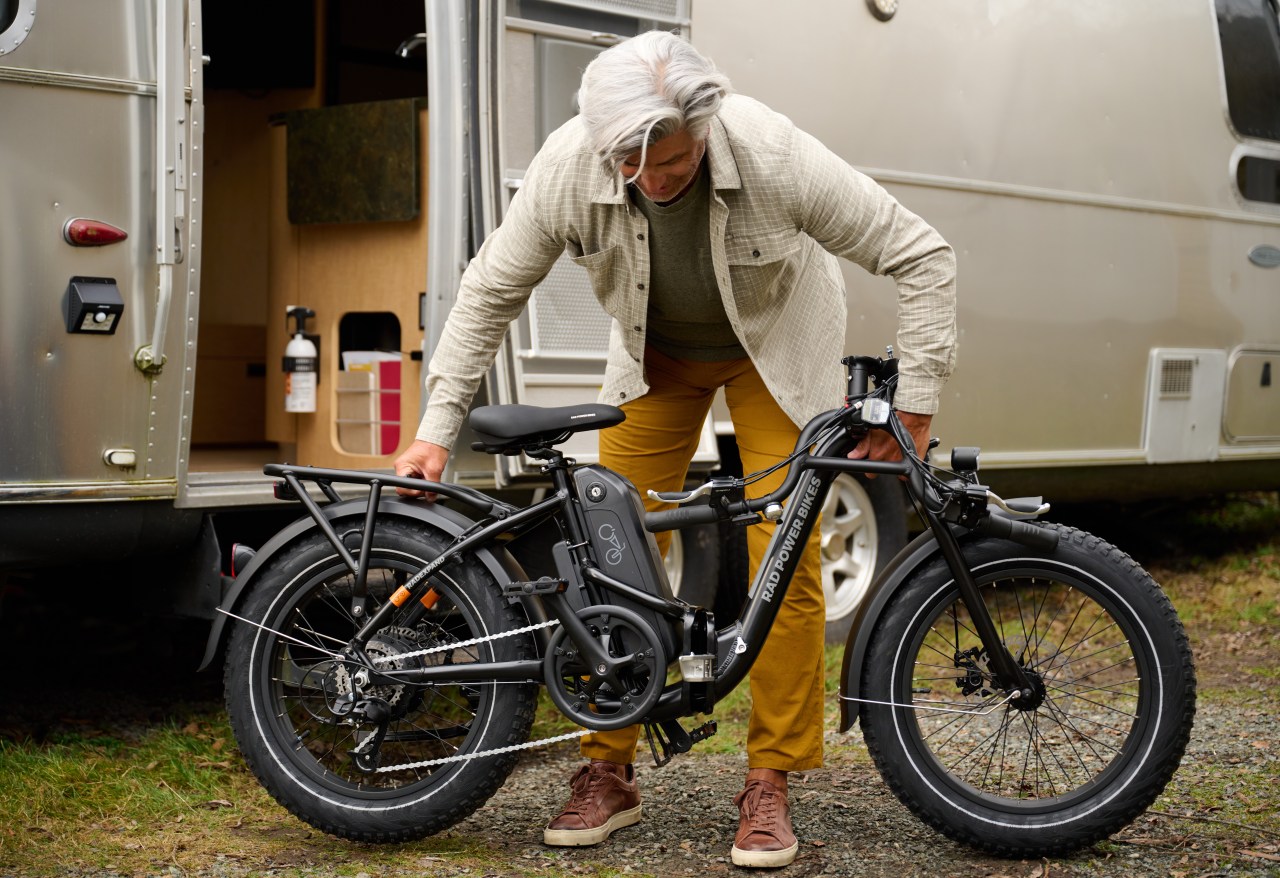 Mature man drops handlebars of RadExpand 5 e-bike outside his airstreamer